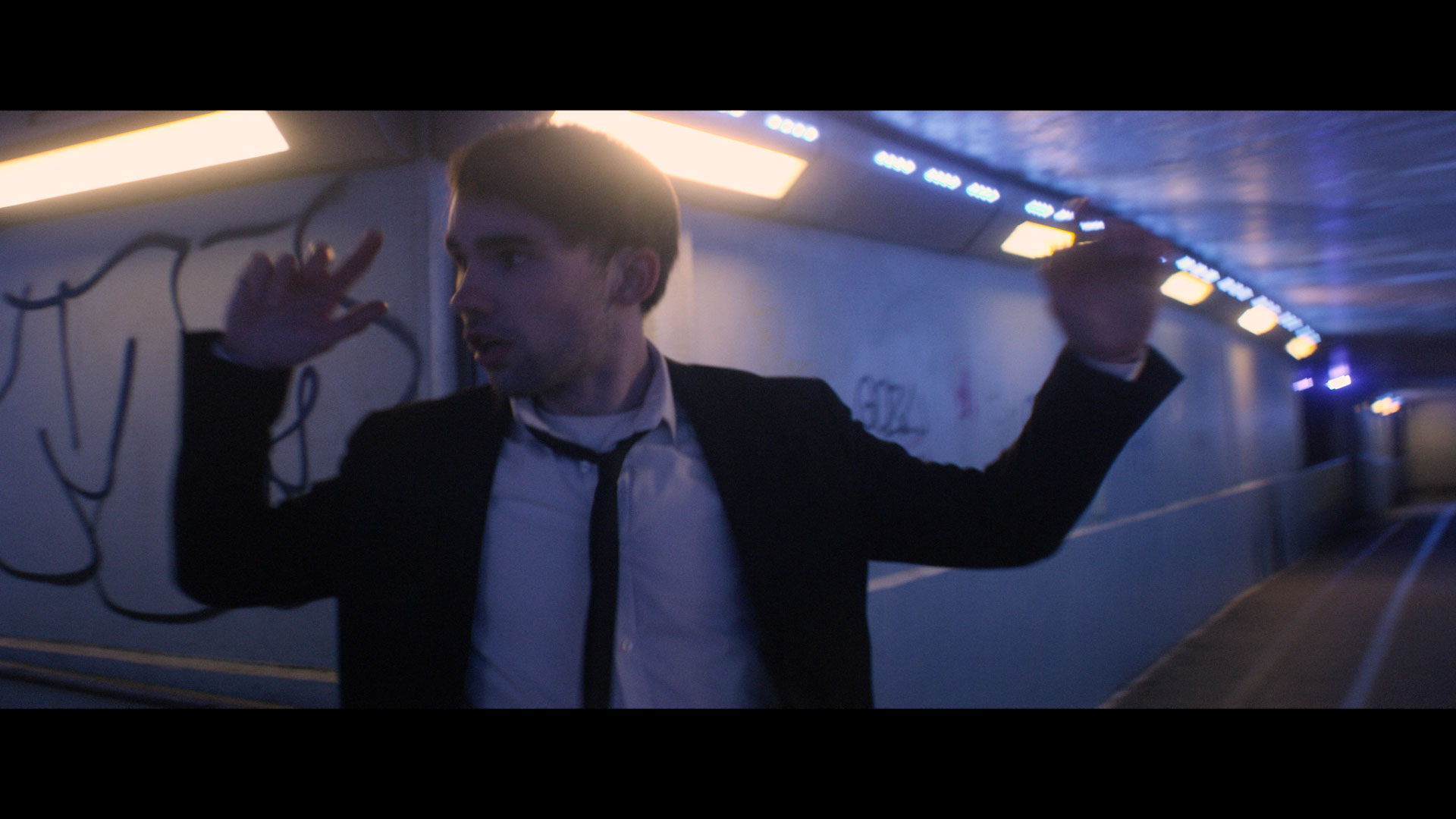 Clockworks - Video Still - Lead singer running through urban city subway